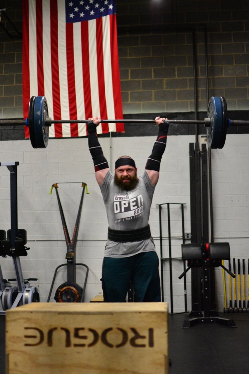 Vadim Snitkovsky lifting a loaded barbell overhead during a training session