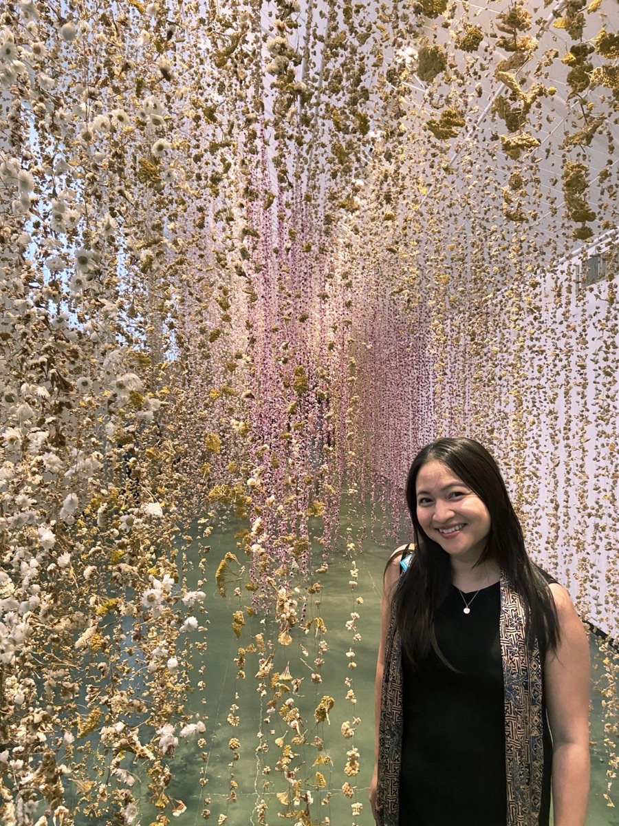 Rosalyn Mahashin, co-founder of Resilient Moment, standing among blossoming trees